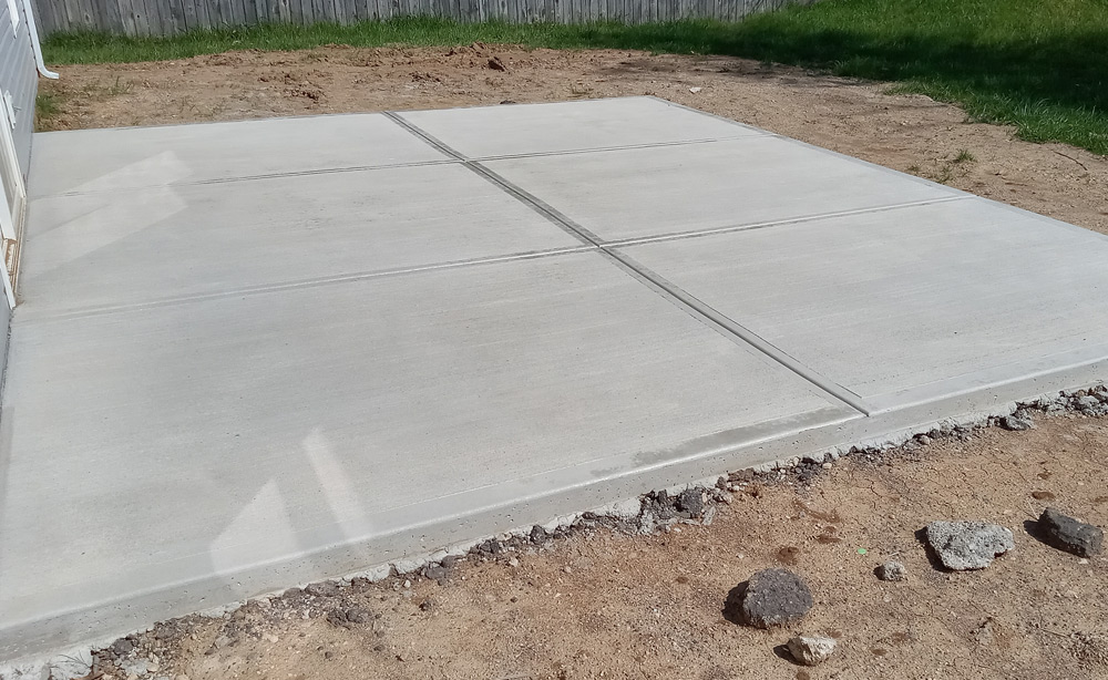 large concrete slap patio behind a home