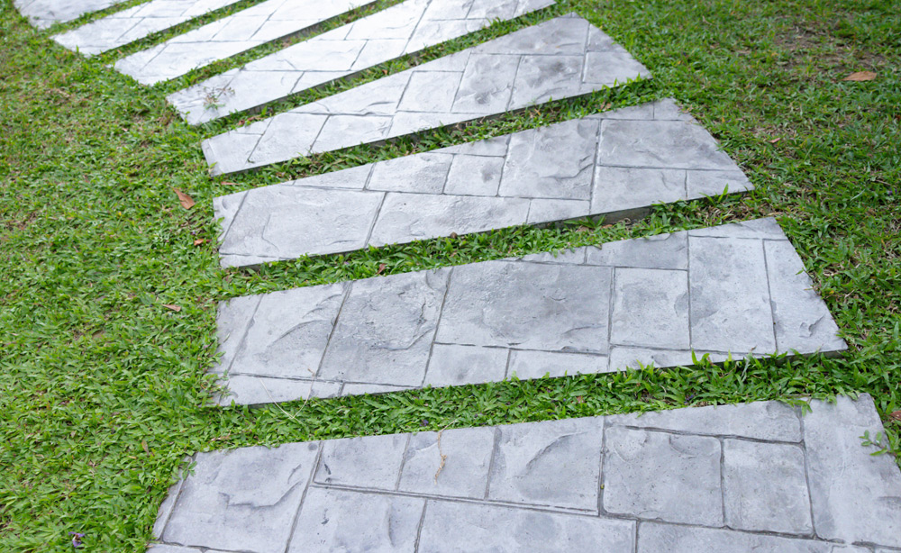 Stamped concrete slab walkway in grass